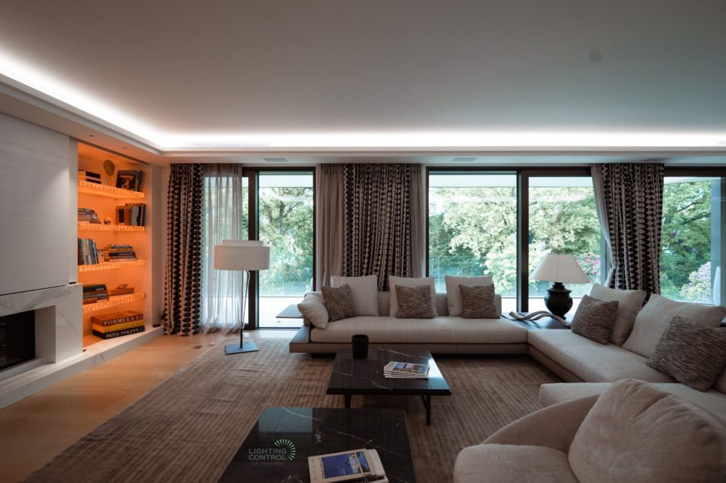 Salon d'un appartement à Genève, corniche lumineuse et bibliothèque rétroéclairée
