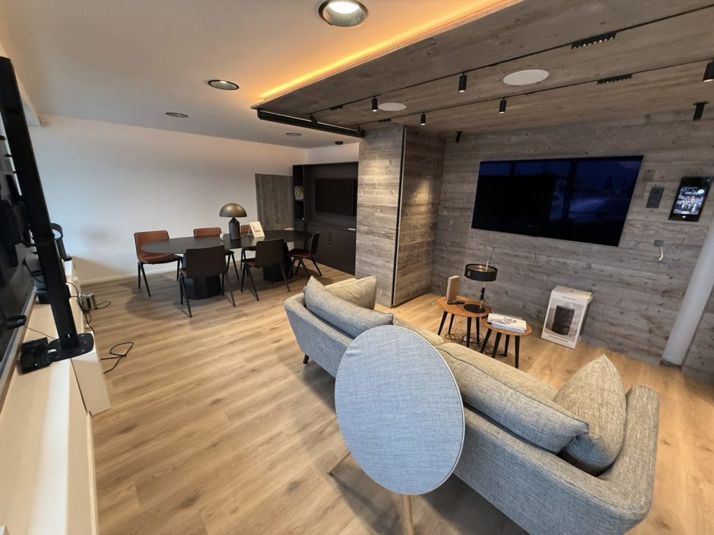 Salon du show-room de Crans-Montana avec TV, enceinte et table de réunion