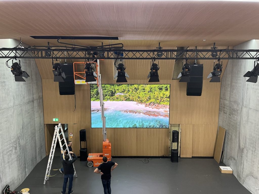 Équipe en installation du mur LED, des line arrays Bose et du pont de projecteurs