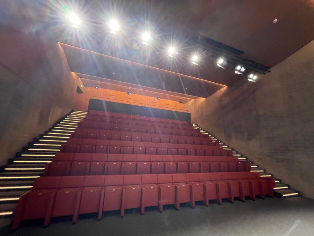 Gradins de l'auditorium éclairés par les projecteurs de scène