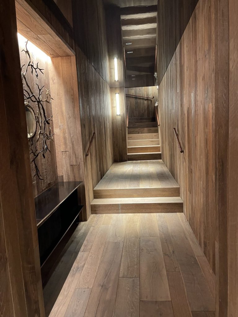 Couloir habillé de bois avec appliques et niche éclairée