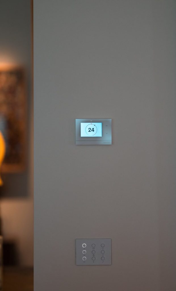 Thermostat Crestron et clavier blanc dans un couloir