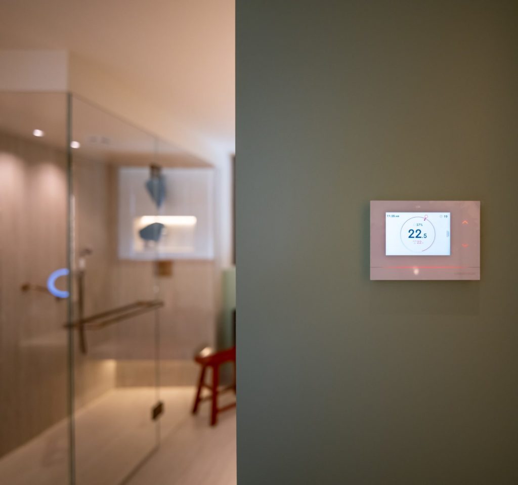 Thermostat tactile Crestron à l'entrée d'une salle de bains