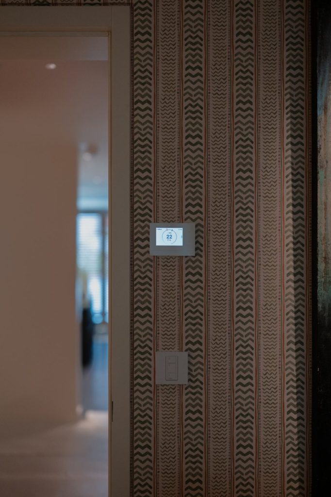 Thermostat Crestron et télécommande Lutron Pico sur papier peint