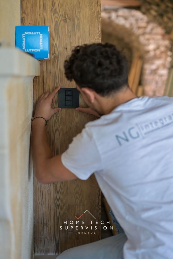 Technicien NG Integration posant un clavier Lutron sur un poteau en vieux bois