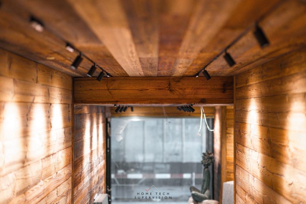 Couloir en vieux bois éclairé par des projecteurs sur rail