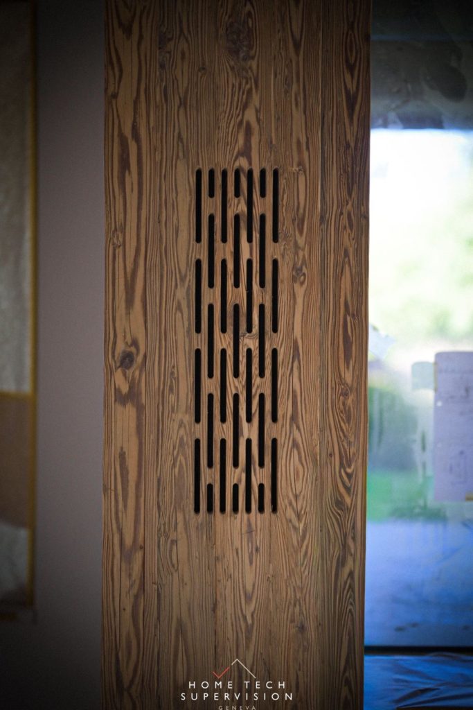 Enceinte invisible derrière une grille découpée dans le vieux bois
