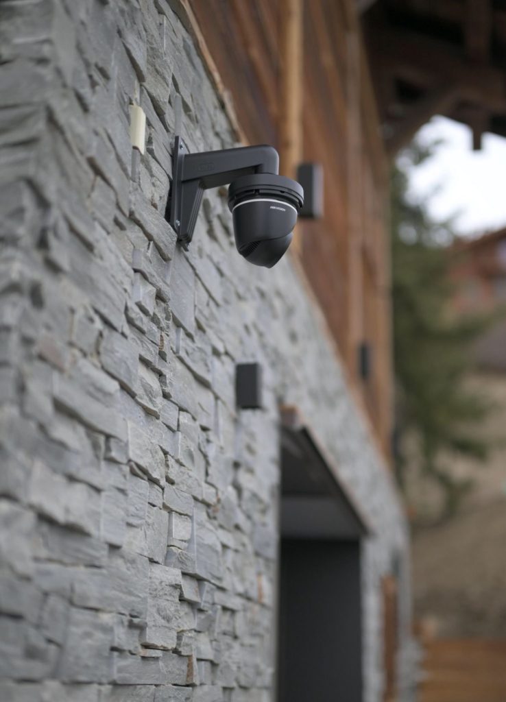 Caméra de vidéosurveillance sur façade en pierre de chalet