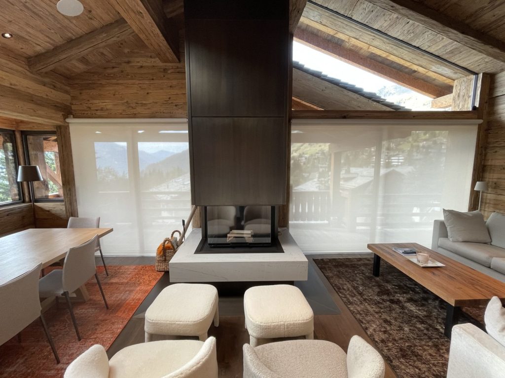 Stores Lutron fermés autour de la cheminée centrale du salon