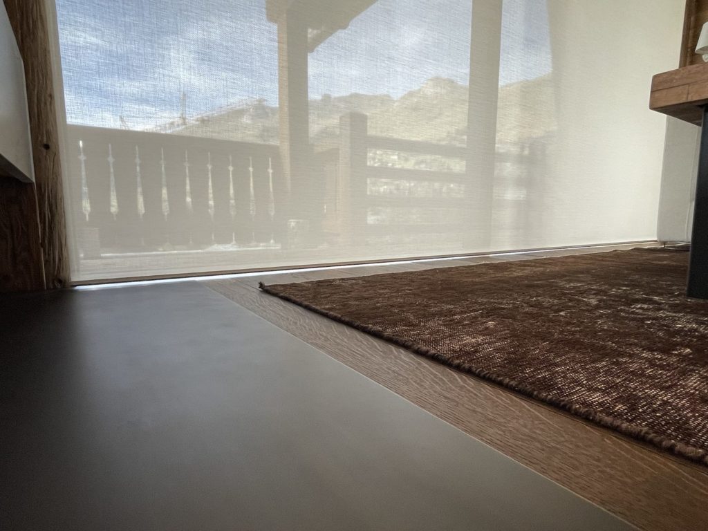 Bas de toile du store Lutron aligné au ras du sol